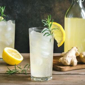 Ginger honey lemonade in a clear glass with a lemon wedge.
