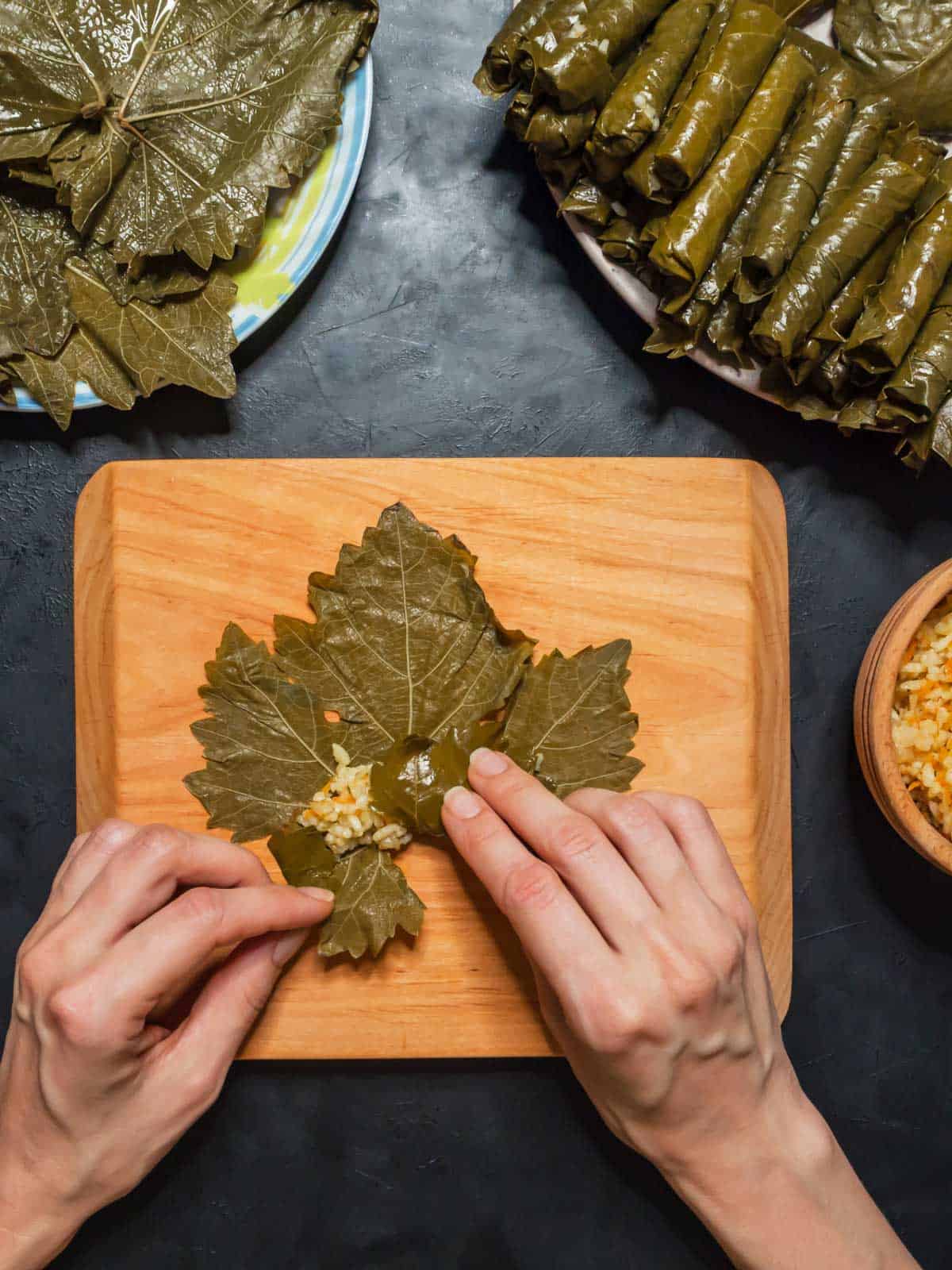 Stuffed grape leaves on a wood board